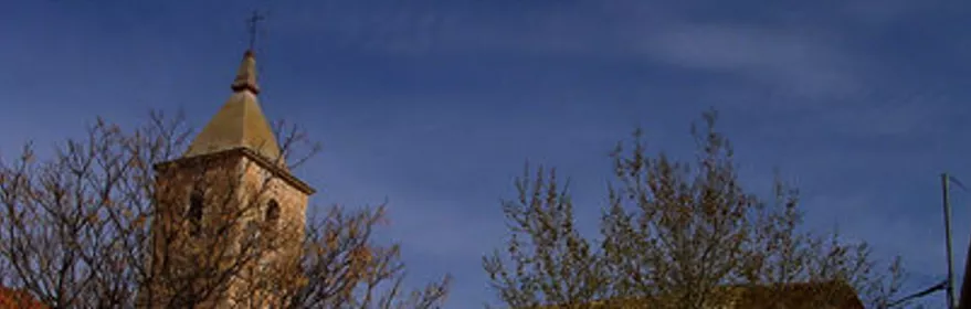 Imagen de la iglesia de Motilleja tras unos árboles