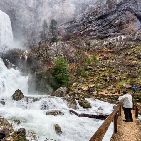 Imagen de varias personas observando la gran cascada del nacimiento del río