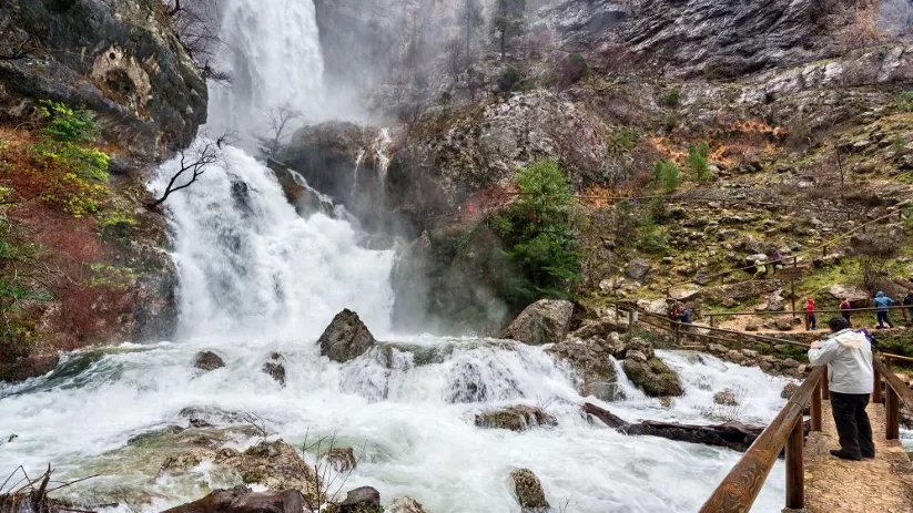 Imagen de varias personas observando la gran cascada del nacimiento del río