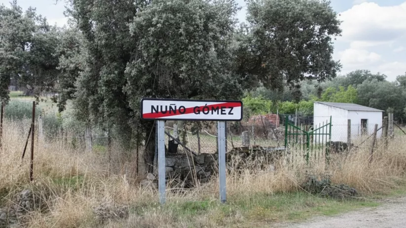 Señal de entrada junto a vegetación seca y una pequeña caseta