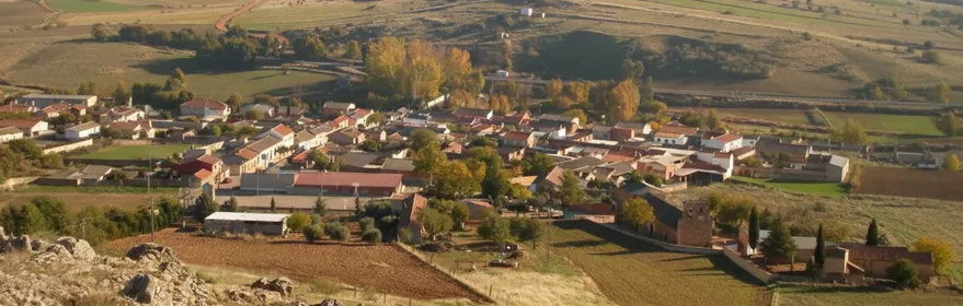 Vista panorámica de Caracuel de Calatrava rodeado de campos de cultivo y suaves colinas.
