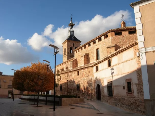 Plaza de Carrión de Calatrava con iglesia de ladrillo y torre campanario al fondo.