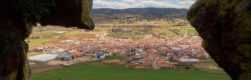 Vista panorámica de Guadalmez (Ciudad Real) desde una cueva natural con el casco urbano y el valle al fondo.