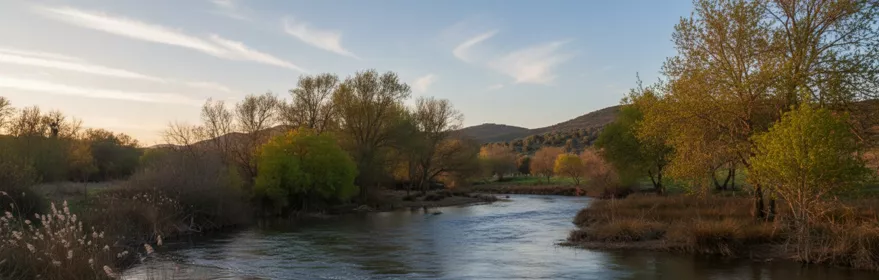 Río Guadiana en Luciana (Ciudad Real), paisaje fluvial con arbolado y colinas al fondo.