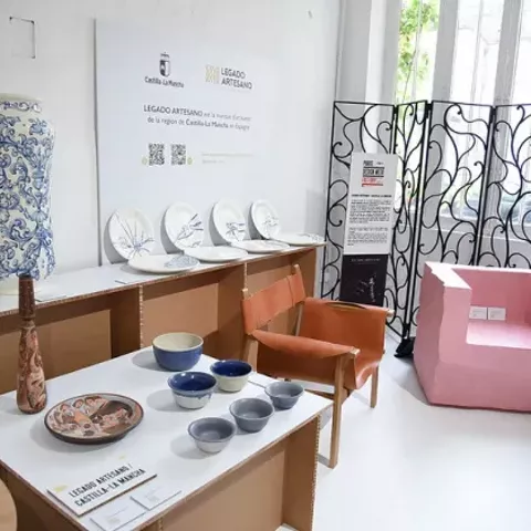 Imagen del stand en la galería con sillones y piezas de cerámica