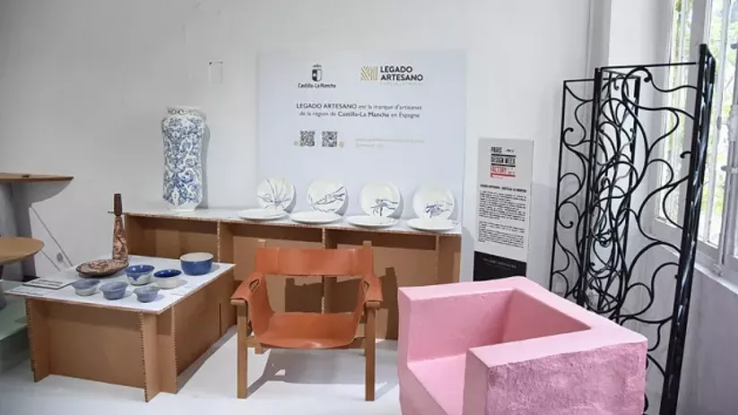 Imagen del stand en la galería con sillones y piezas de cerámica
