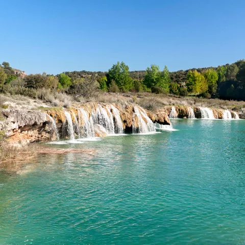 Imagen de pequeñas cascadas sobre la laguna azul