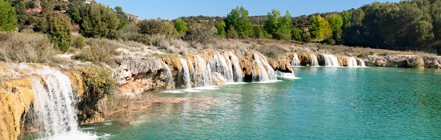Imagen de pequeñas cascadas sobre la laguna azul