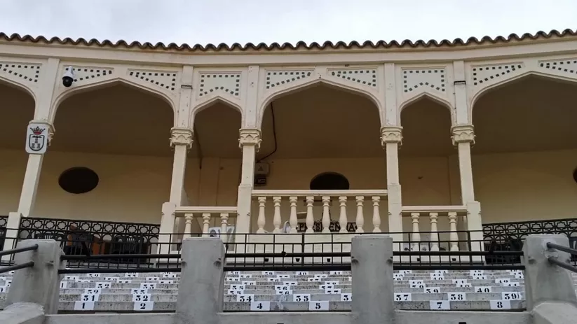 Detalle de galería superior con arcos, barandilla y asientos.