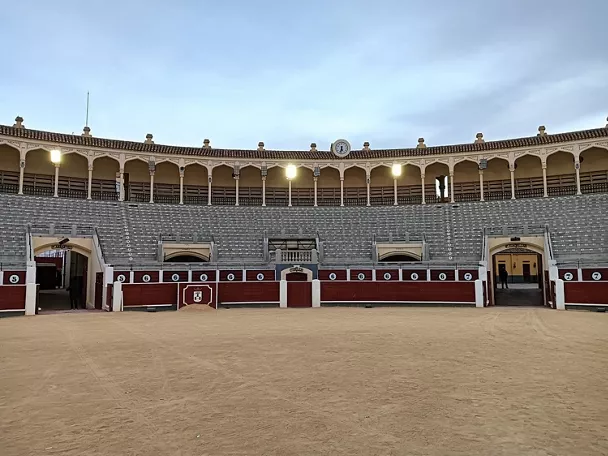 Vista frontal de graderío con barreras numeradas y arena central.