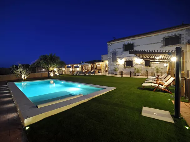 Vista exterior nocturna de Casa Rural Alma del Tajo, casa rural de 5 estrellas en Albarreal de Tajo (Toledo), con piscina privada, amplios jardines y zonas exteriores para grupos y familias.