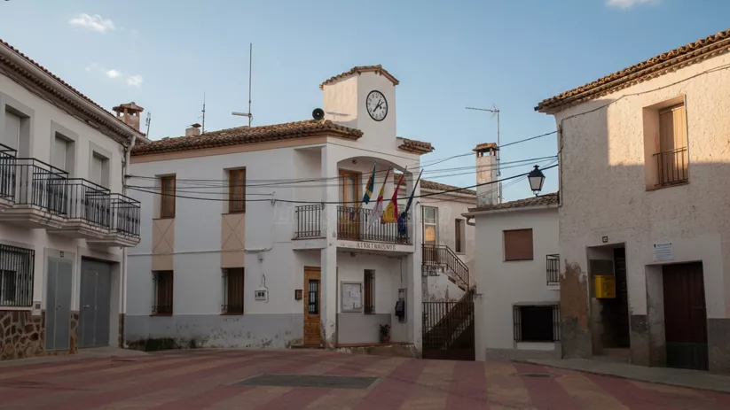 Ayuntamiento blanco con reloj en una plaza