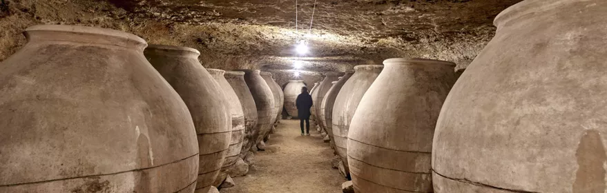 Imagen de bodega de vino subterránea con tinajas de barro