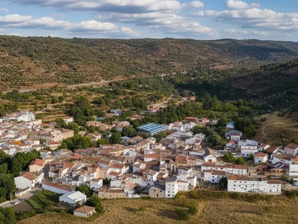 Vista aérea de un núcleo rural rodeado de colinas y campos.