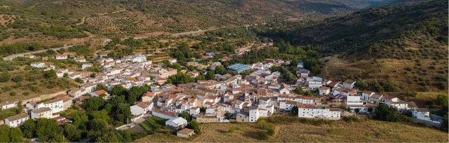 Vista aérea de un núcleo rural rodeado de colinas y campos.