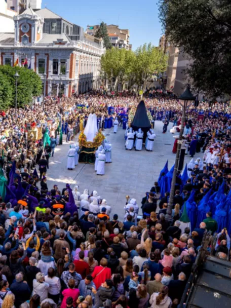 Desfile procesional con varios pasos y numerosos asistentes en plaza amplia.