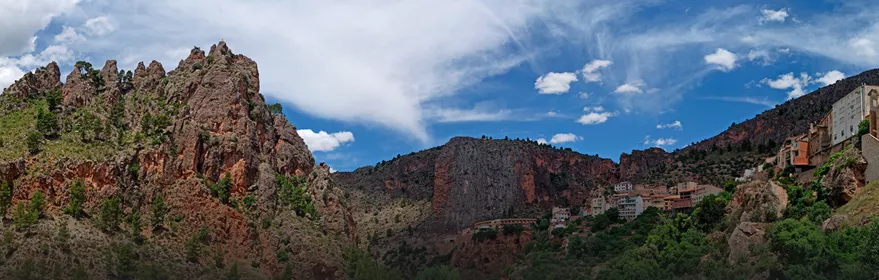 Panorámica de formaciones rocosas y viviendas encajadas en un entorno montañoso