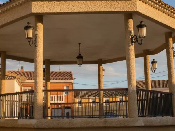 Quiosco octogonal en la plaza de Pozo Cañada rodeado de farolas y viviendas.