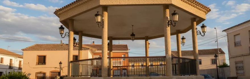 Quiosco octogonal en la plaza de Pozo Cañada rodeado de farolas y viviendas.