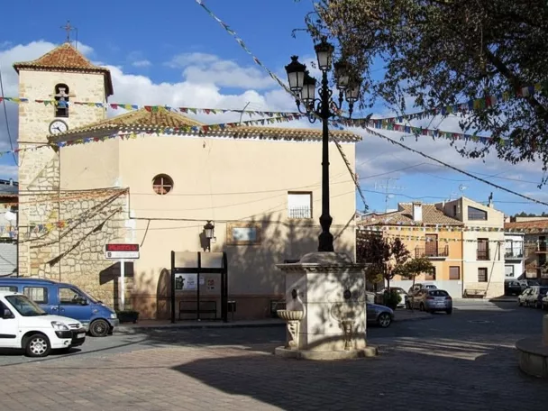 Plaza de Pozo Lorente con fuente central y la iglesia parroquial al fondo.