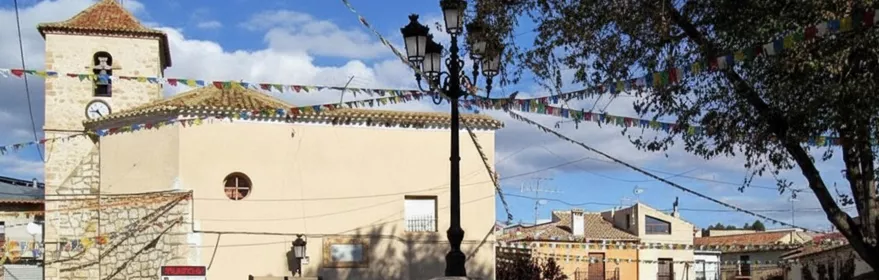 Plaza de Pozo Lorente con fuente central y la iglesia parroquial al fondo.
