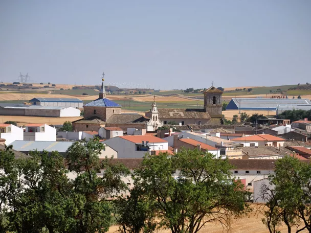 Vista panorámica de un pueblo con tejados y campos alrededor.
