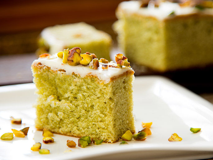 Pistachio sponge cake covered in icing sugar.