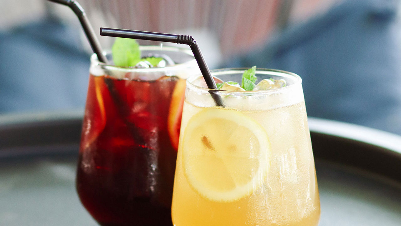 Two colorful drinks with straws