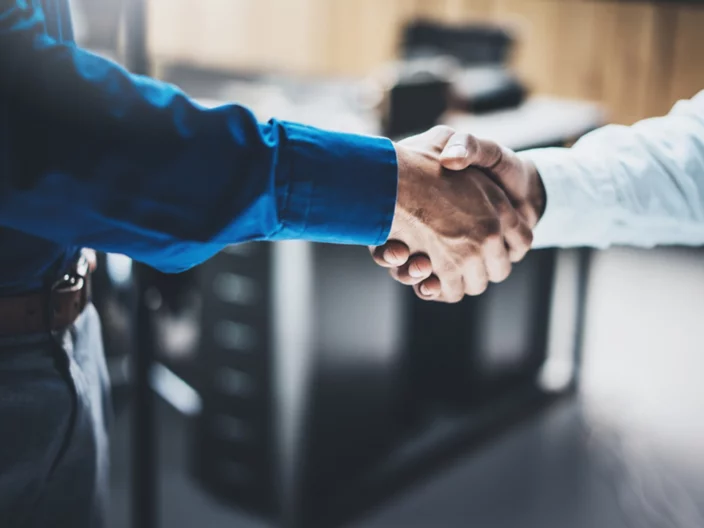 Business partnership handshake concept.Closeup photo of two businessmans handshaking process.Successful deal after great meeting.Horizontal, blurred background.