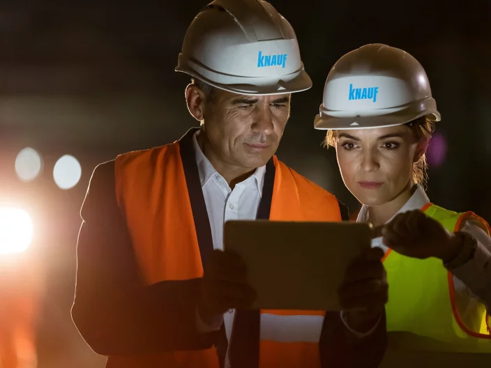 Construction worker engineer using digital tablet at dark construction site