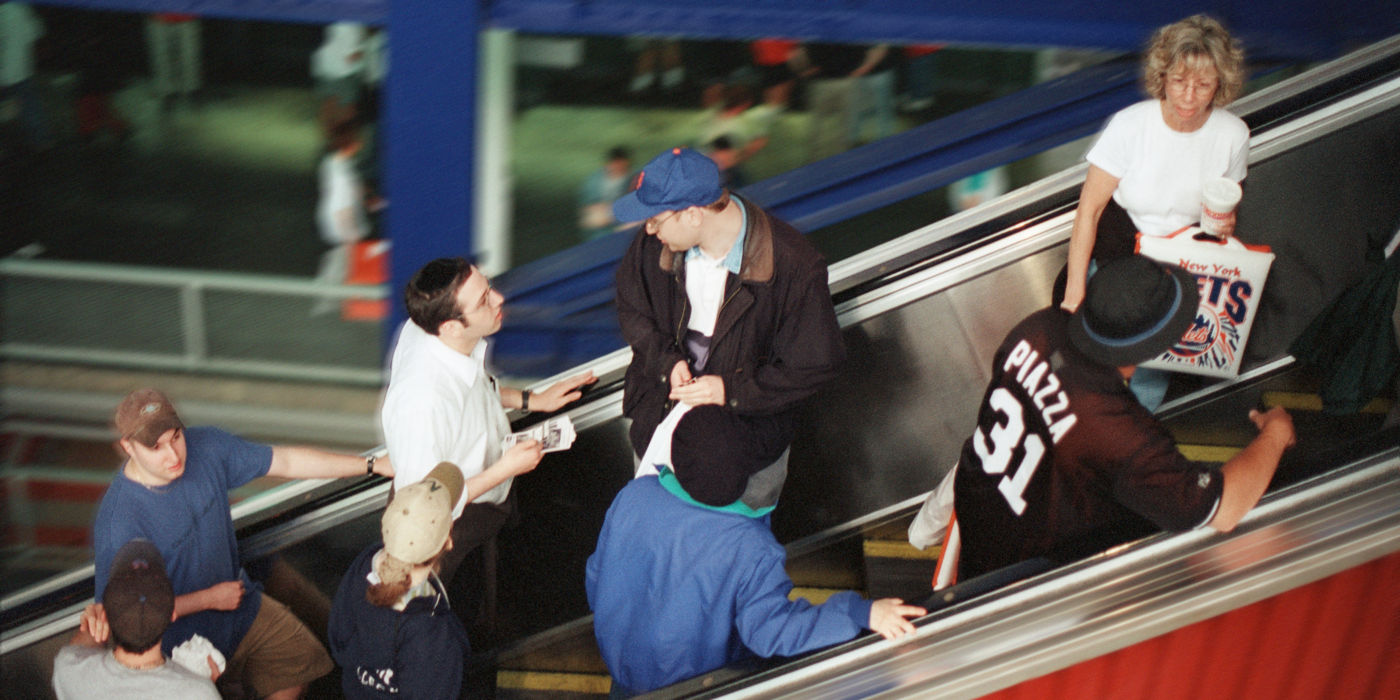 People taking escalator at sports arena.