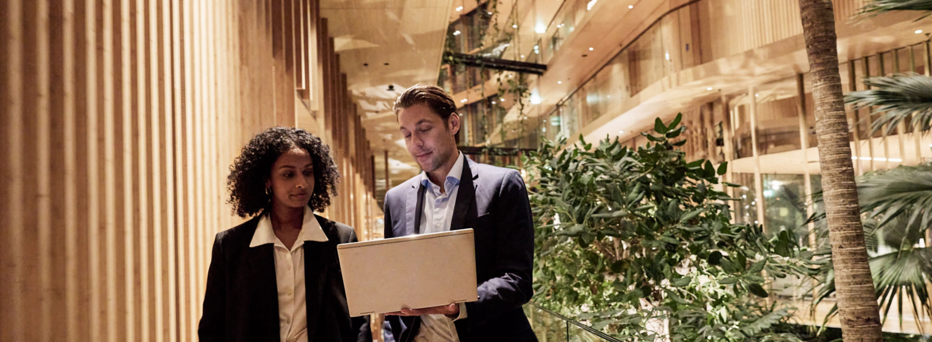 Businessman and businesswoman looking at a laptop and talking at the hotel Jakarta Amsterdam.