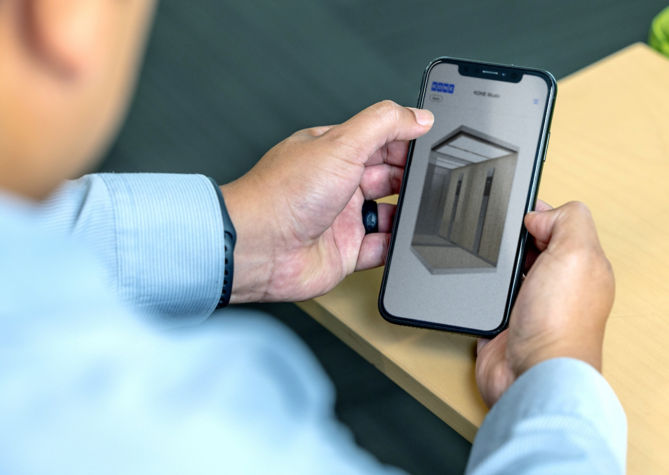 Man looking at a smartphone screen with 3D visuals on it.