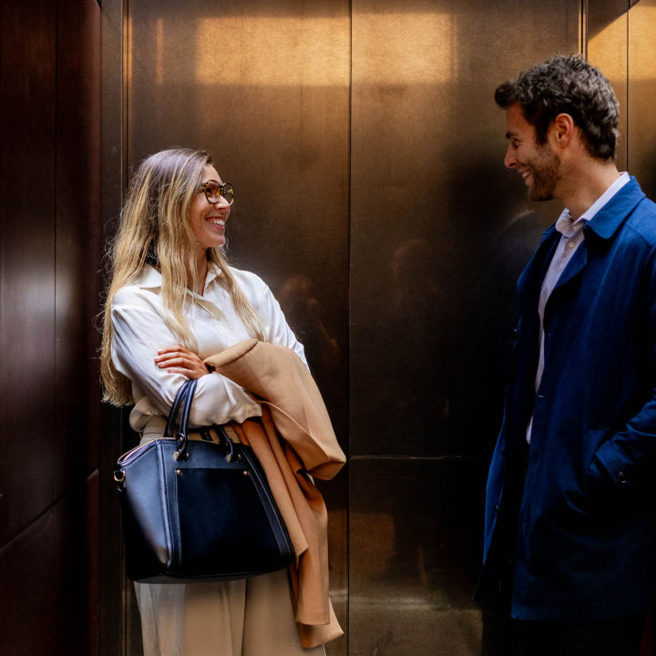 Twee lachende mensen in een duurzame KONE lift