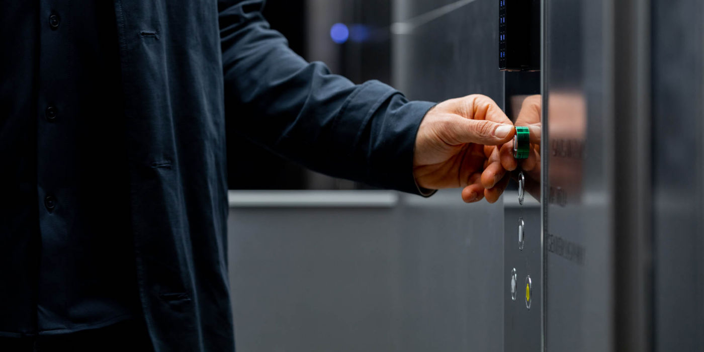 Man in an elevator car pressing the elevator button.