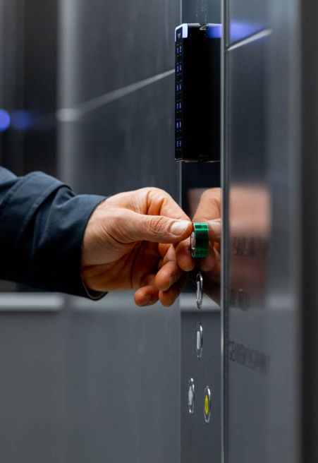 Man in an elevator car pressing the elevator button.