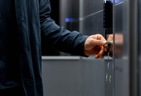 Man in an elevator car pressing the elevator button