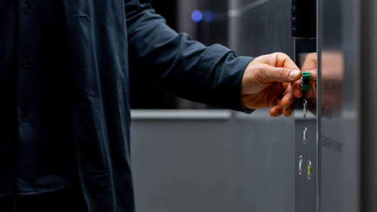 Man in an elevator car pressing the elevator button.