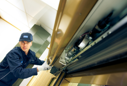 KONE maintenance technician working on automatic doors.