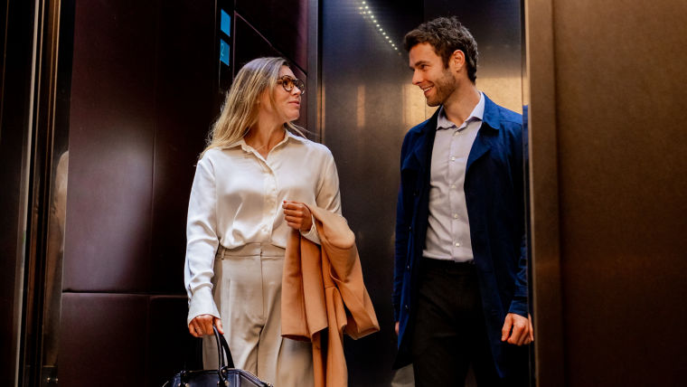 Hombre y mujer de negocios saliendo de un elevador
