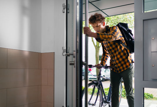 Cyclist_struggling_with_door_in_residential_building_1:535x365