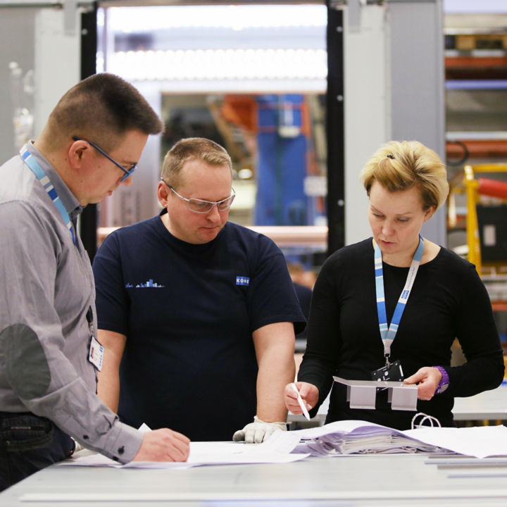 Team of KONE employees discussing about production.