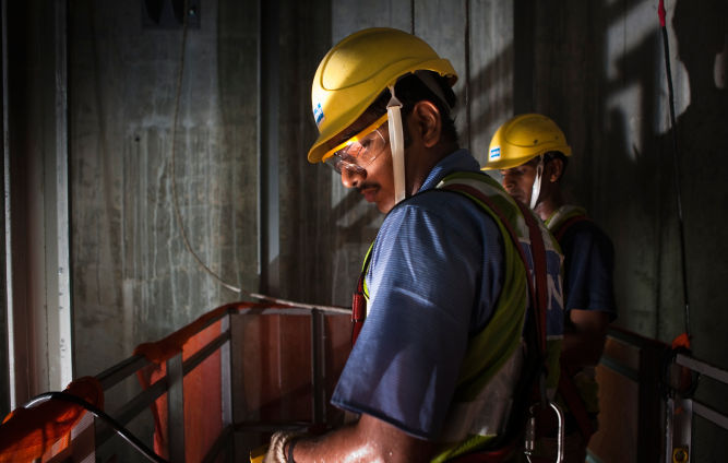 Dos técnicos de mantenimiento KONE dando servicio a elevador