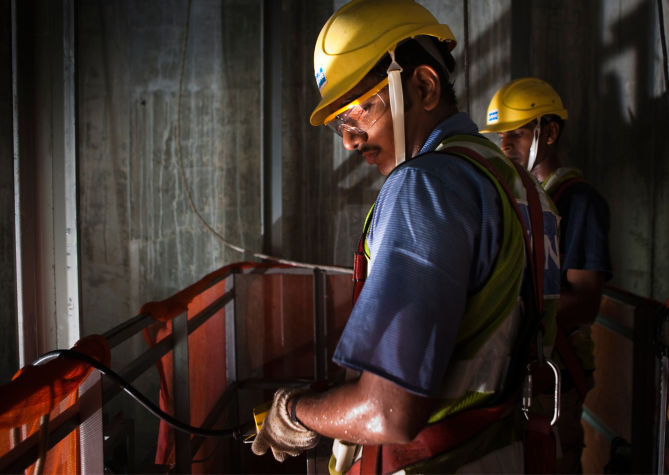 Dos técnicos de mantenimiento KONE dando servicio a elevador