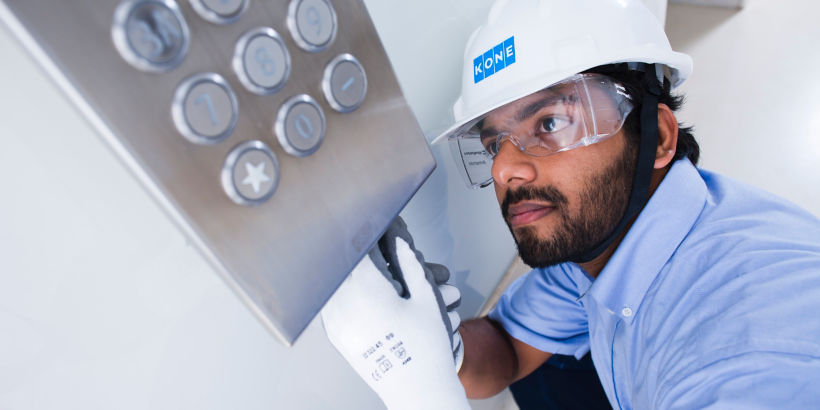 Técnico de mantenimiento de elevador revisando botonera