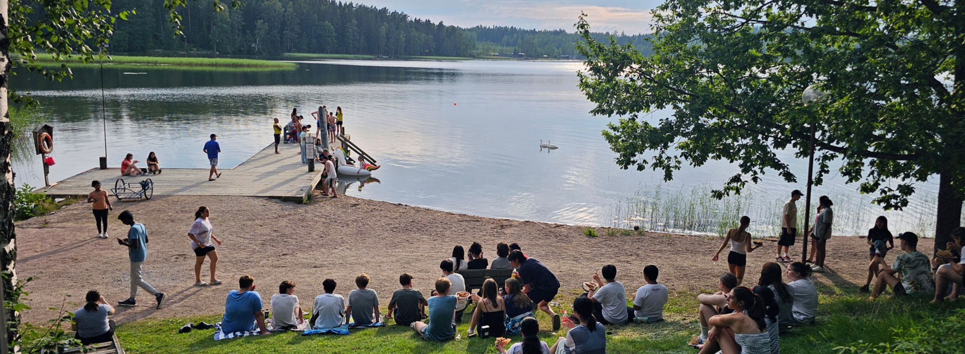 Young people sitting by the lake at KONE Global Youth Camp.
