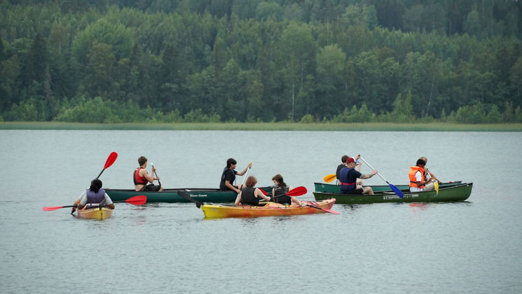 Group of people canoeing on a lake at KONE Global Youth Camp.
