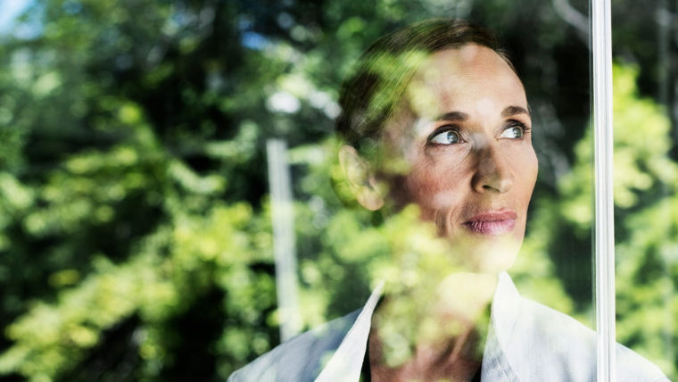Woman behind window with reflection