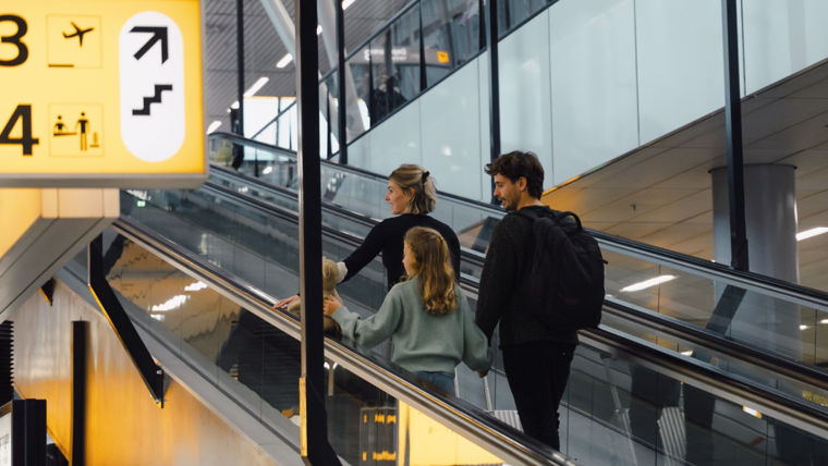 Family using KONE escalator at the Schiphol Airport.