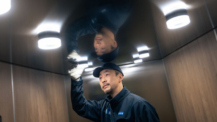 KONE Technician checking the lights of the car ceiling